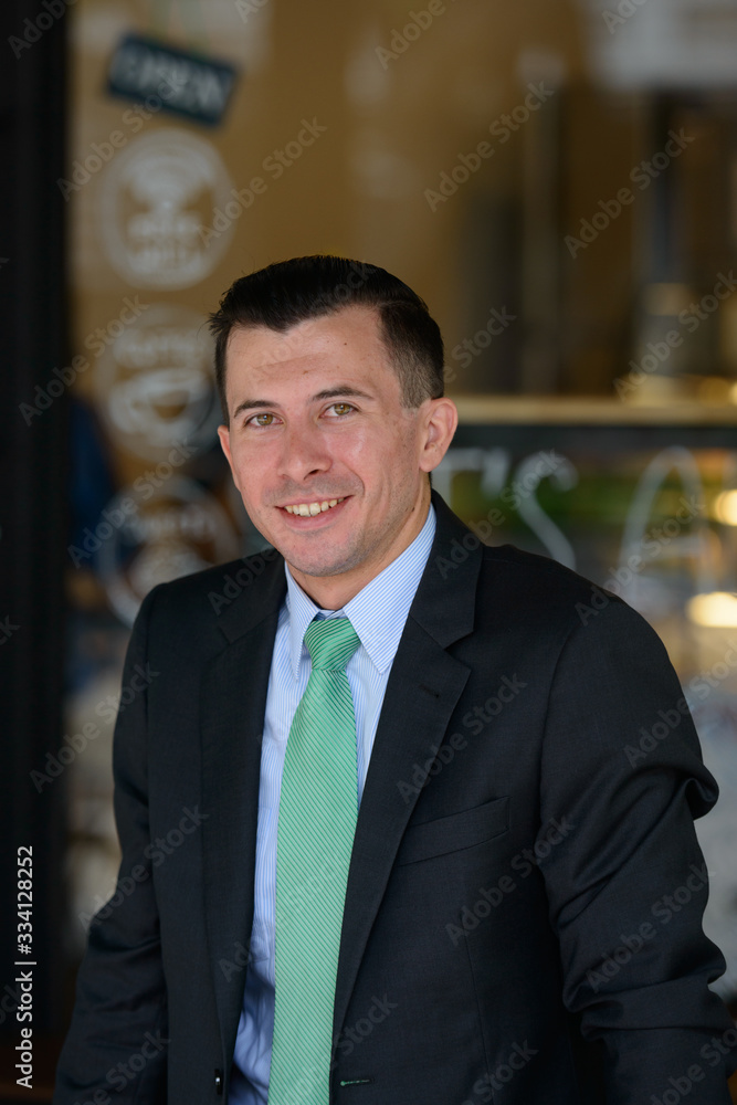 Happy young businessman smiling at the coffee shop outdoors Happy young businessman smiling at the coffee shop outdoors