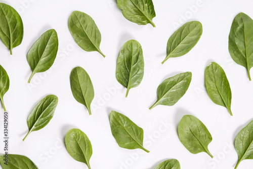 Clean eating concept. Leaves ripe juicy freshly picked organic baby spinach greens laid in pattern, isolated on white background. Healthy diet for spring summer detox. Vegan raw food. Close up.