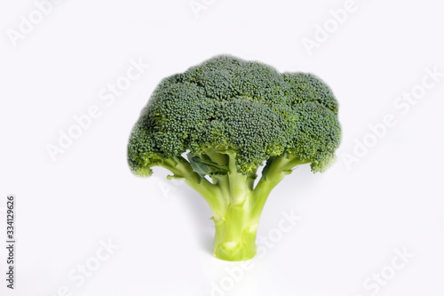 Clean eating concept. Single ripe juicy freshly picked organic broccoli head. One green curd isolated on white background. Healthy diet for spring summer detox. Vegan raw food. Close up.