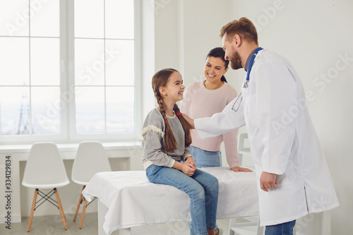 Family mom and daughter are smiling at a visit to a doctor male pediatrician in the clinic.