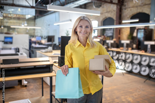 Blonde woman holding boxes and paper packege photo