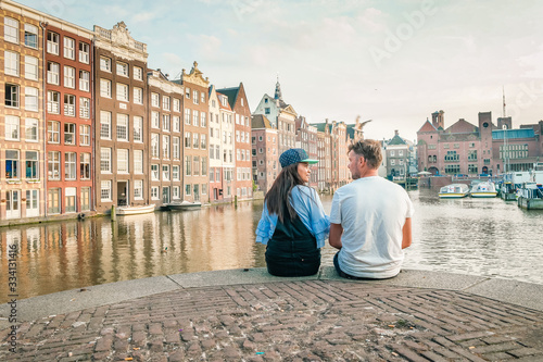 Amsterdam Damrak during sunset, happy couple man and woman on a summer evening at the canals photo