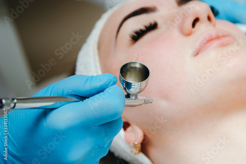 Woman receiving face treatment in beauty spa salon. Oxygen dermapen therapy. Skin treatment. photo