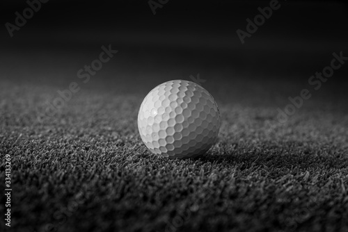 Golf ball put on grass at course with dramatic style.