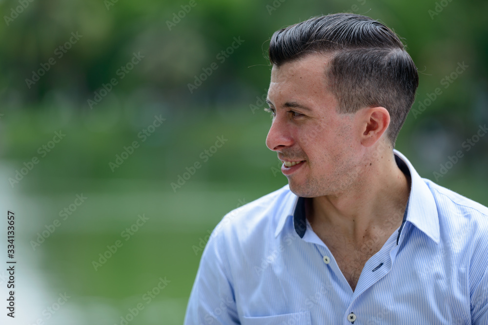 Closeup profile view of young handsome businessman at the park Closeup profile view of young handsome businessman at the park