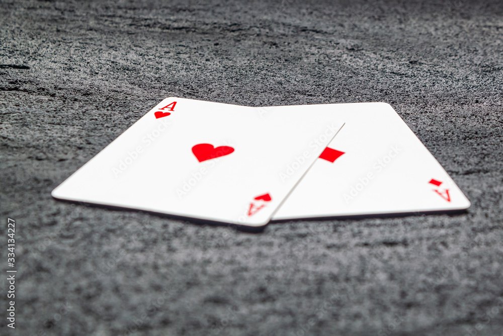 Obraz premium two red aces heart and diamond on black concrete dark background .copy space