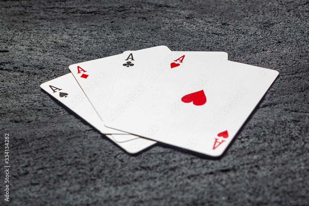 four aces playing cards on black concrete dark background .copy space