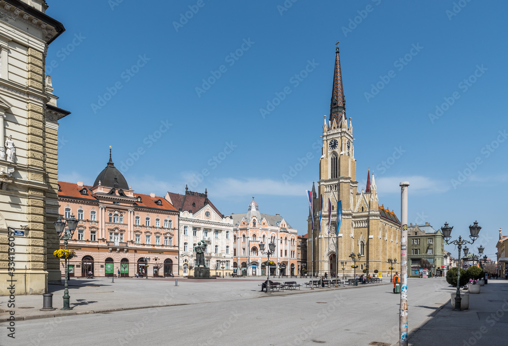 Obraz premium Novi Sad, Serbia city center with cathedral and old buildings with small group of people almost empty during the coronavirus or covid-19 isolation.