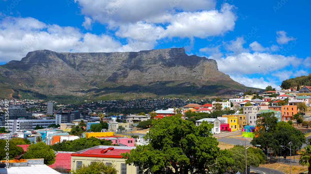 Beautiful view from Bo-Kaap or Malay at sunny day with Table Mountain on background. The city of Cape Town is a famous travel destination in Africa. Vivid colors filtered. February 2020