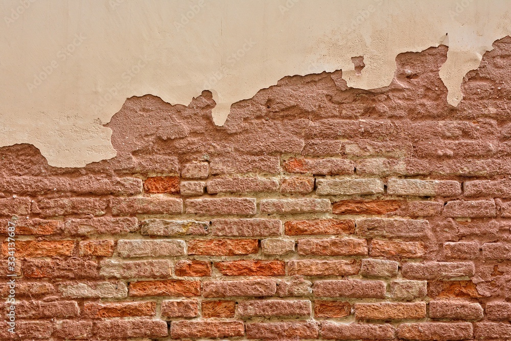 Fototapeta premium Old brick wall with peeling plaster.