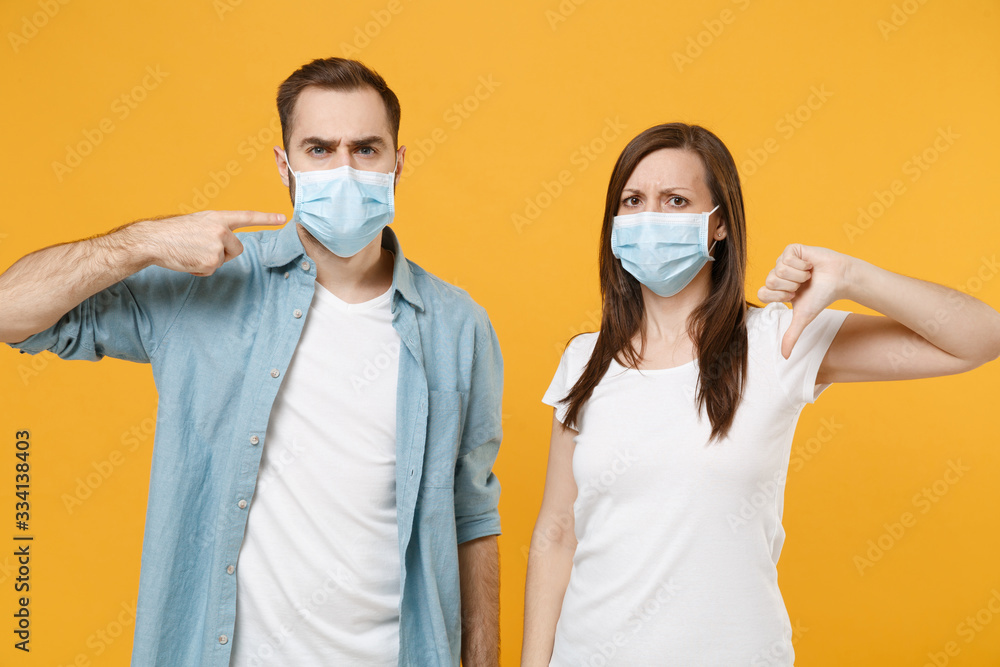 Two people in sterile face masks white t-shirts isolated on yellow background studio. Epidemic pandemic rapidly spreading coronavirus 2019-ncov medicine flu virus ill sick disease treatment concept. Two people in sterile face masks white t-shirts isolated on yellow background studio. Epidemic pandemic rapidly spreading coronavirus 2019-ncov medicine flu virus ill sick disease treatment concept.