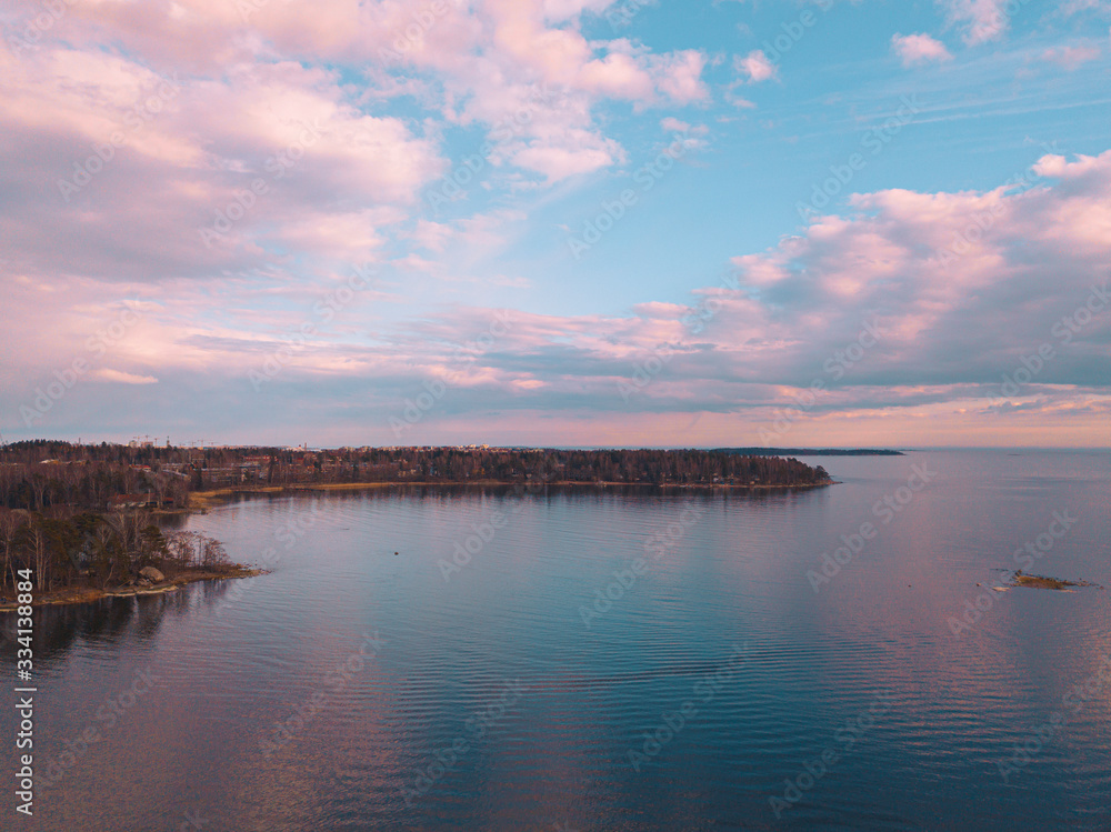 Helsinki islands. Scandinavian sea landscape. Beautiful sunset with reflection of clouds in the sea Aerial top down drone shot.