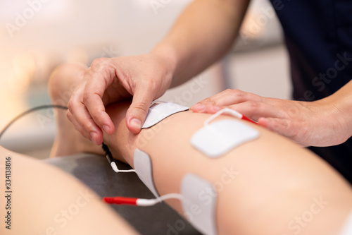 Electro stimulation in physical therapy to a young woman photo