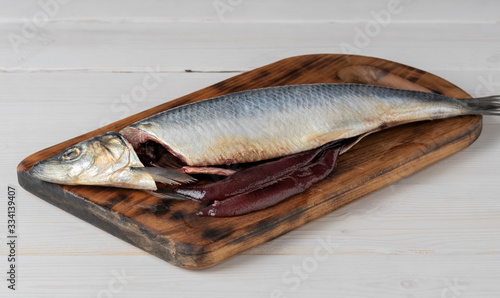 Salted herring on a cutting board, the process of cooking dishes from herring. Close-up. Country style photo