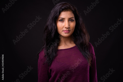Face of young beautiful Indian woman looking at camera