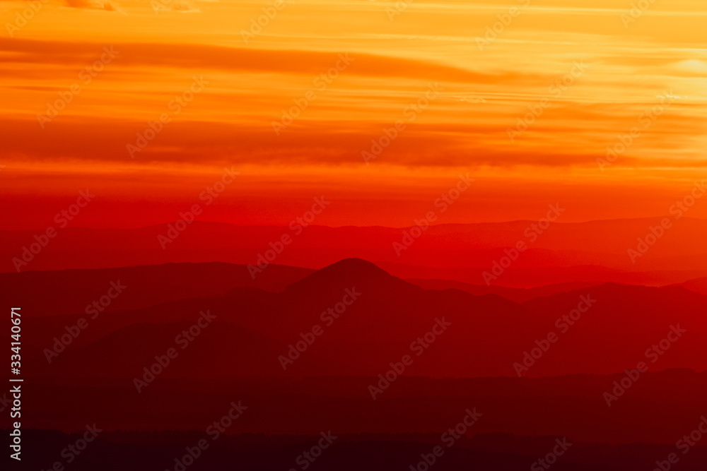 Fototapeta premium Tranquil landscape of layered mountains silhouettes during colorful sunrise, Slovakia