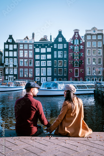 Amsterdam Damrak during sunset, happy couple man and woman on a summer evening at the canals photo