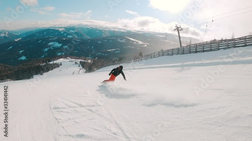 Snowboarder having fun, making turns, going downhill on a slope in ski resorts