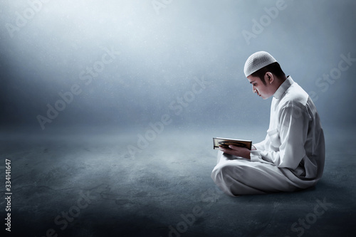 Religious muslim man reading holy quran