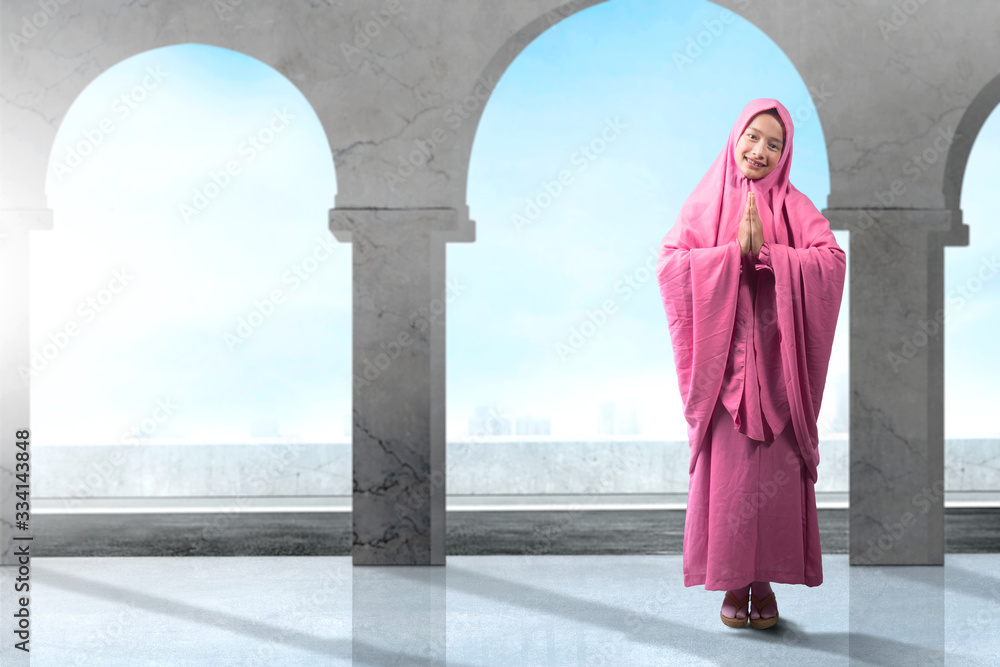 Asian Muslim woman in veil praying