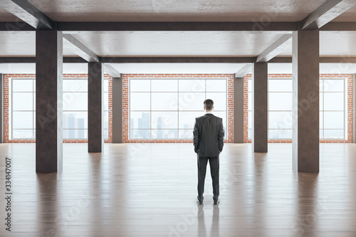 Businessman standing in clean interior with columns