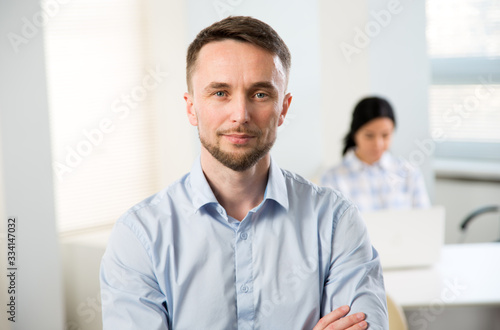 Portrait of businessman and his colleague on the background at the office