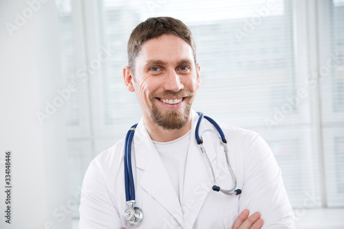 Portrait of young doctor on modern clinic background.