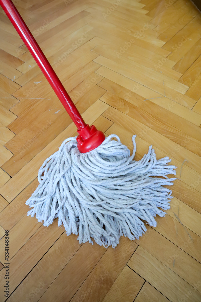 isolated cleaning mop with red wooden stick on wooden home floor,parquet,  cleaning and disinfection of surfaces Stock Photo | Adobe Stock