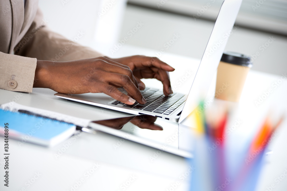 Close-up of hands of businesswoman typing on a laptop.