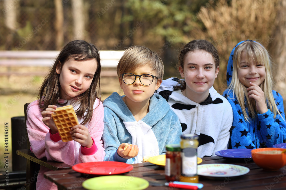 Obraz premium friends are laughing outside at breakfast on a sunny day