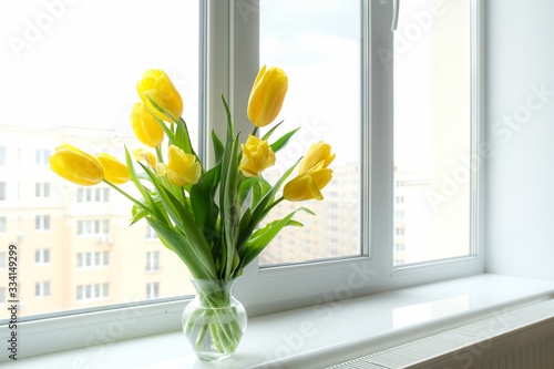 Bouquet of yellow tulips on the windowsill.Concept of giving and receiving flowers and gifts.
