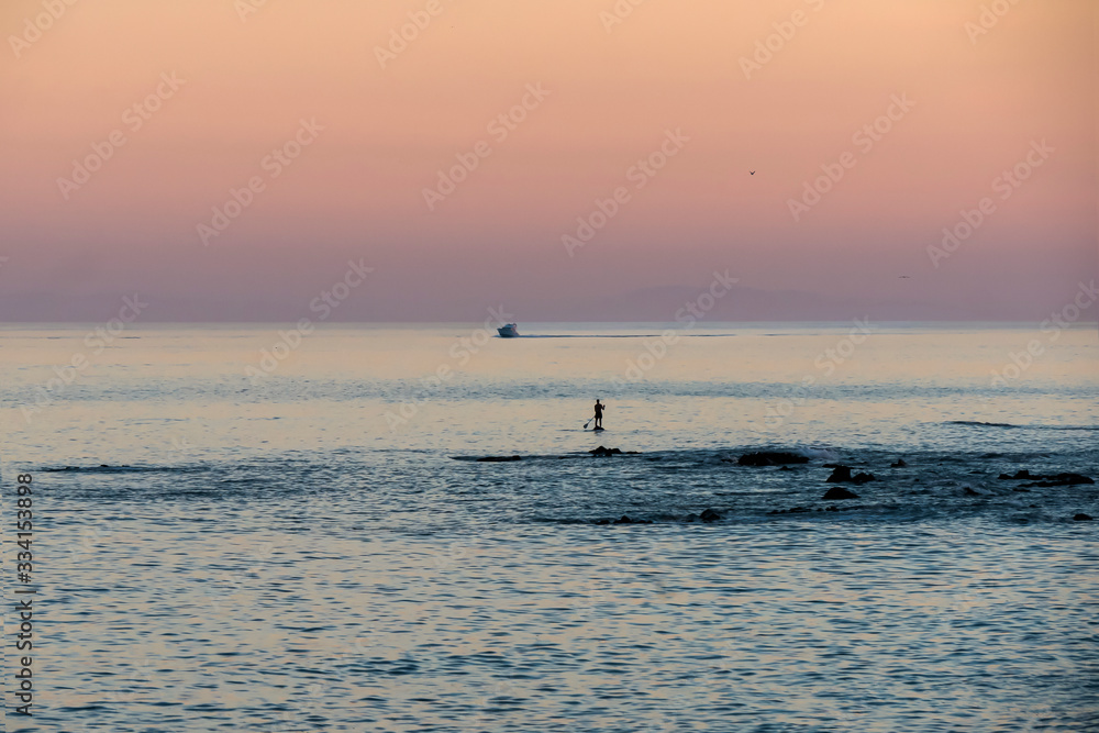 man practices the sport of paddle surf in the mediterranean