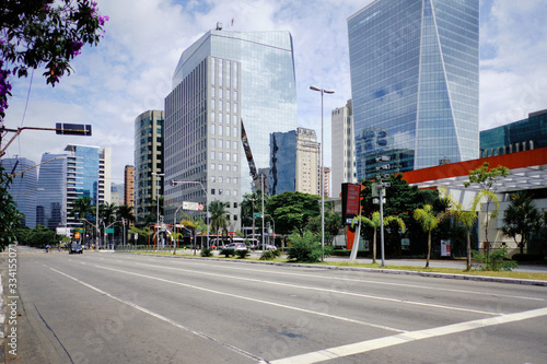 Empty Juscelino Kubitschek Avenue with some cars  during coronavirus outbreak  Sao Paulo  Brazil with some cyclists - March 2020