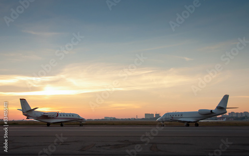 Two jet planes parking at the airport. Small private airplanes at the airport parking..Passenger airplanes parked with nice sky. Space for text.
