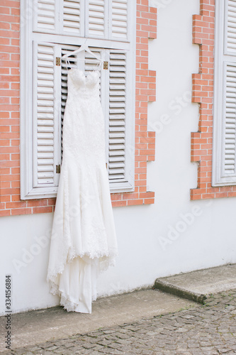 A white wedding dress hanged on the hanger. Buying a wedding dress.