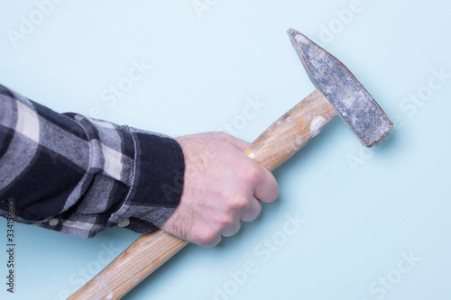 hammer in male hand on a colored background