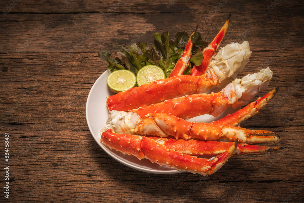 Cooked Organic Alaskan King Crab Legs with lemons,Alaskan King Crab on vintage wooden background. Cooked Organic Alaskan King Crab Legs with lemons,Alaskan King Crab on vintage wooden background.