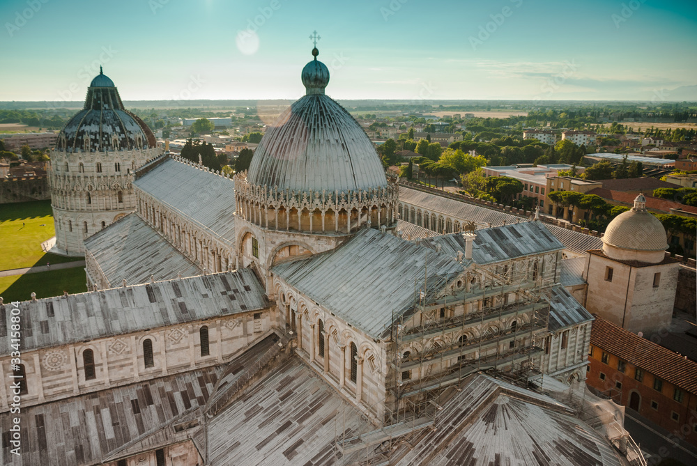 Pisa Cathedral. Birds eye view on Pisa cityscape and UNESCO sites Duomo of Santa Maria Assunta Cathedral and Baptistry of St John. Roof tops sunset from Leaning tower of Pisa on Piazza dei Miracoli