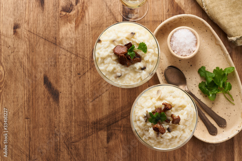 Risotto with mushrooms in wine glass. Unconventional unusual serving. Top view, copy space