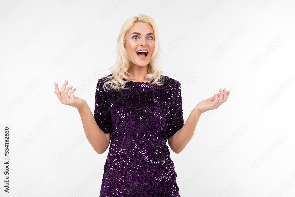 charming surprised blonde girl in purple beautiful elegant dress on a white background with copy space charming surprised blonde girl in purple beautiful elegant dress on a white background with copy space