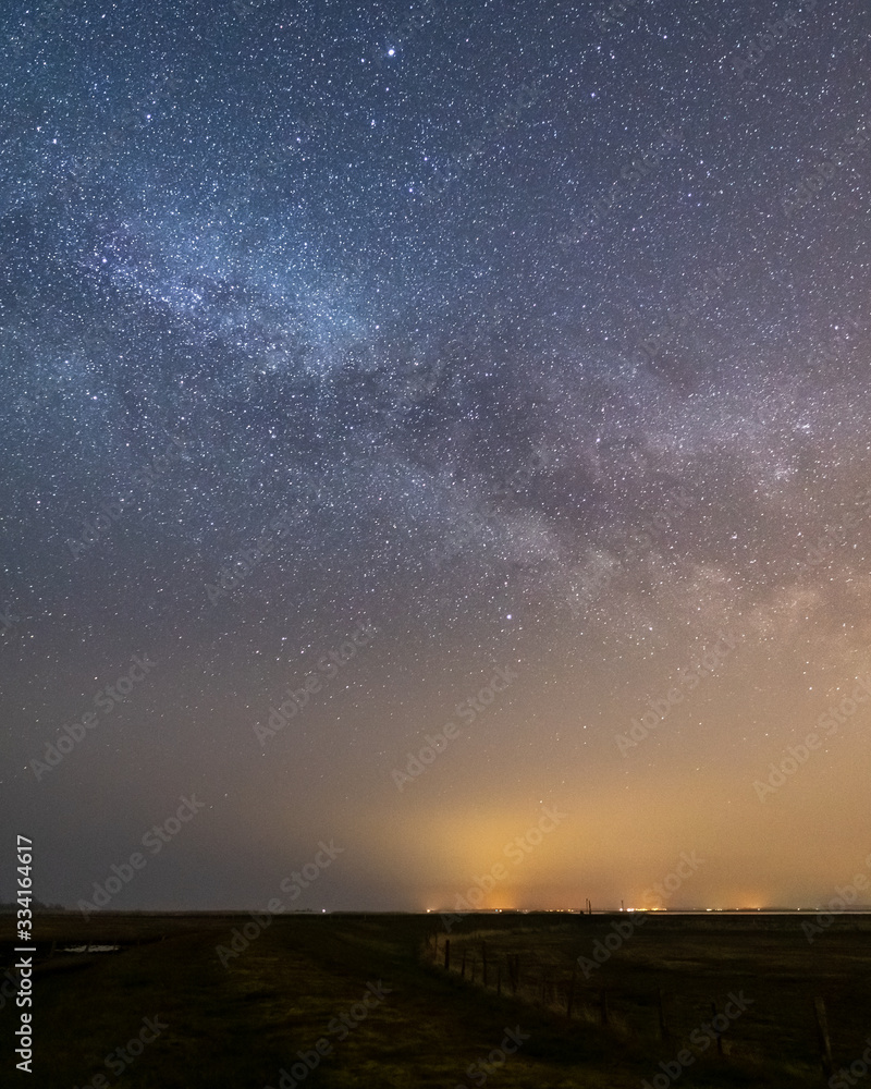 Landscape night shot with the milky way and a dyke and a moor in the forground