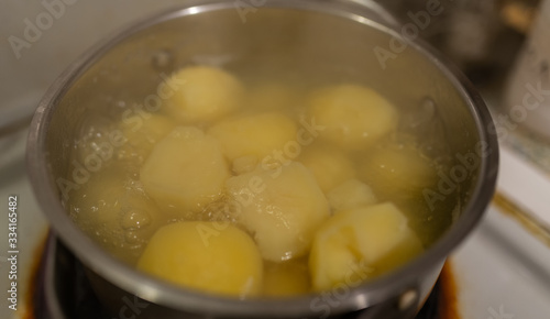Potatoes cooking in pot at kitchen. Selective focus.