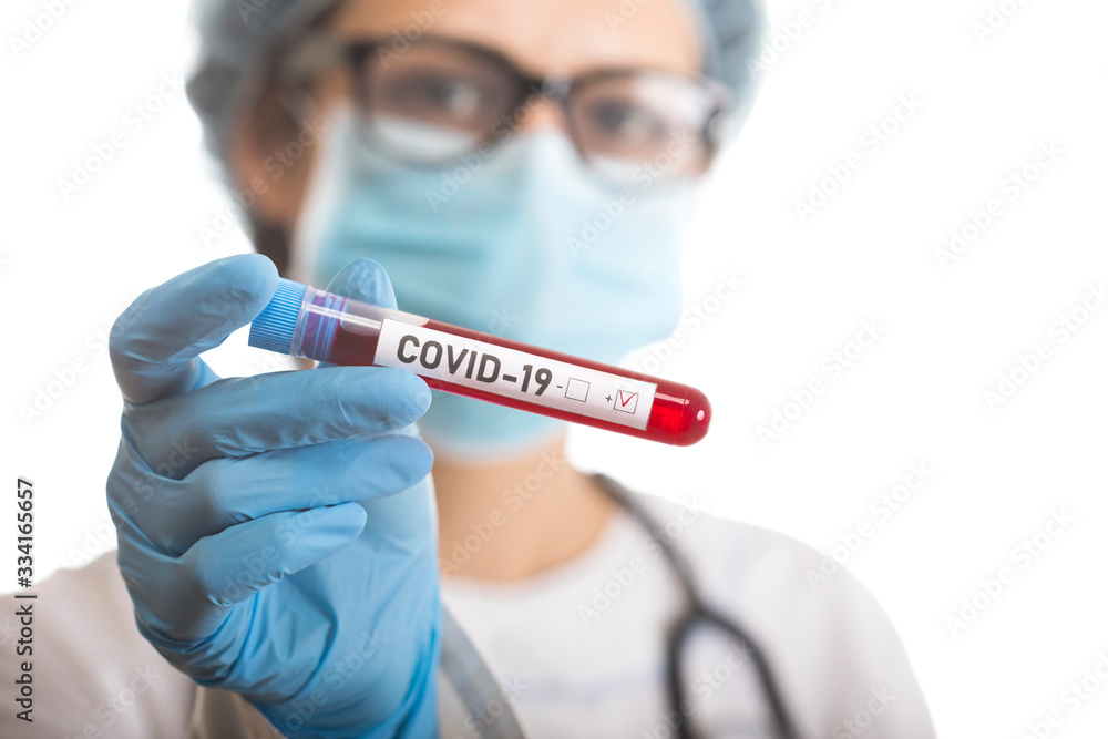 Microbiologist with a tube of biological sample contaminated by Coronavirus with label Covid-19 Microbiologist with a tube of biological sample contaminated by Coronavirus with label Covid-19