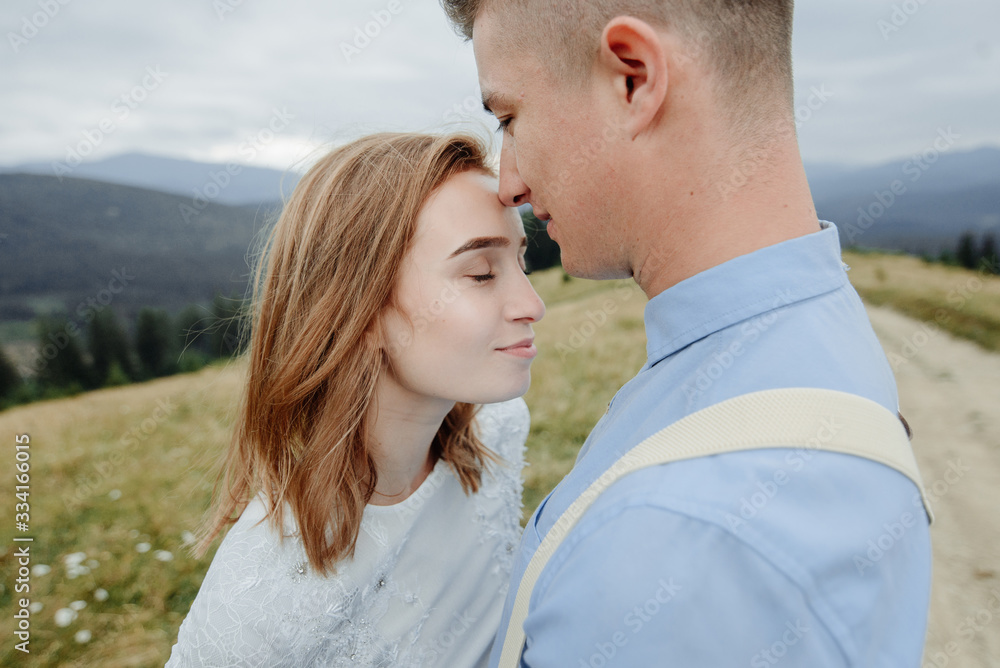 Photoshoot of the bride and groom in the mountains. Boho style wedding photo.