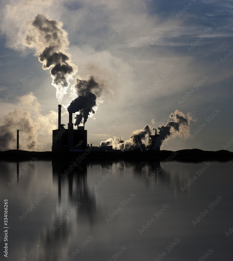 Factory polluting the environment, reflected in water