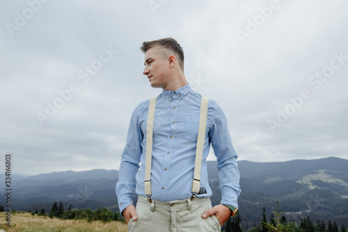 Photoshoot of the groom in the mountains. Boho style wedding photo.