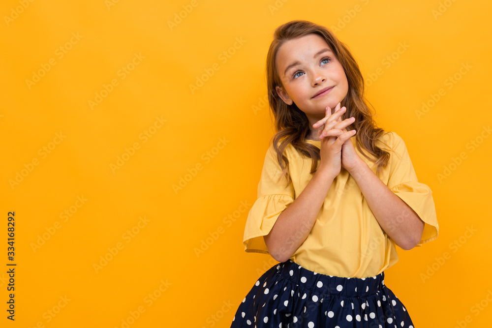 stylish girl in a yellow T-shirt posing like a model on a yellow background with copy-space stylish girl in a yellow T-shirt posing like a model on a yellow background with copy-space