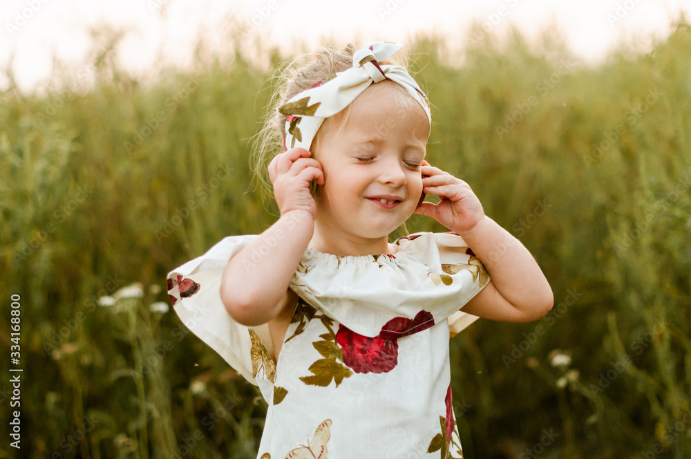 Little smiling girl playing a game with macaroons like listening to music Little smiling girl playing a game with macaroons like listening to music