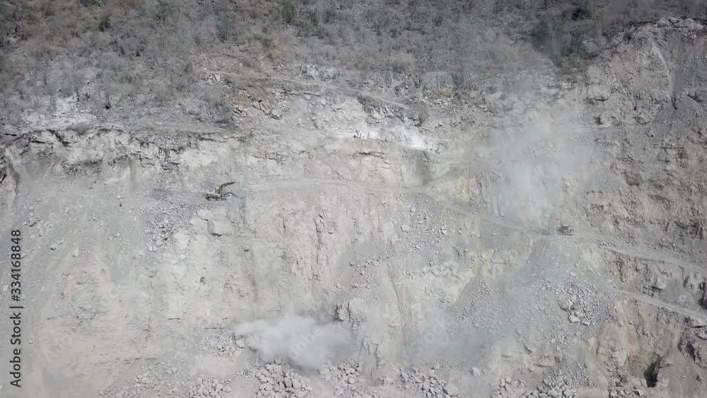 aerial sliding shot of excavators mucking out broken rocks from the quarry mountain aerial sliding shot of excavators mucking out broken rocks from the quarry mountain