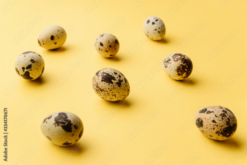 Several quail eggs lie on a yellow background. Several quail eggs lie on a yellow background.